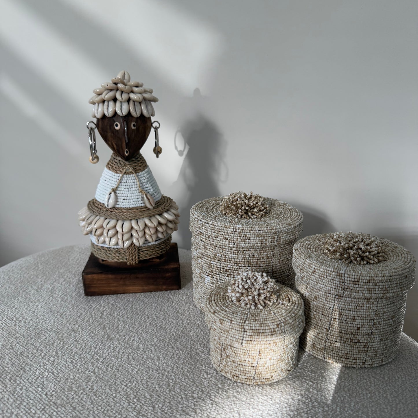 Handgemaakte Namji Doll houten pop van circa 25 cm met witte glaskralen, kauri schelpen en oorbellen, uniek cultureel decoratiestuk