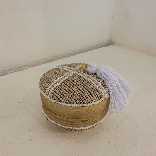 Handgemaakt bamboe kralendoosje met wit kruispatroon van glaskralen op beige achtergrond, afkomstig uit Indonesië